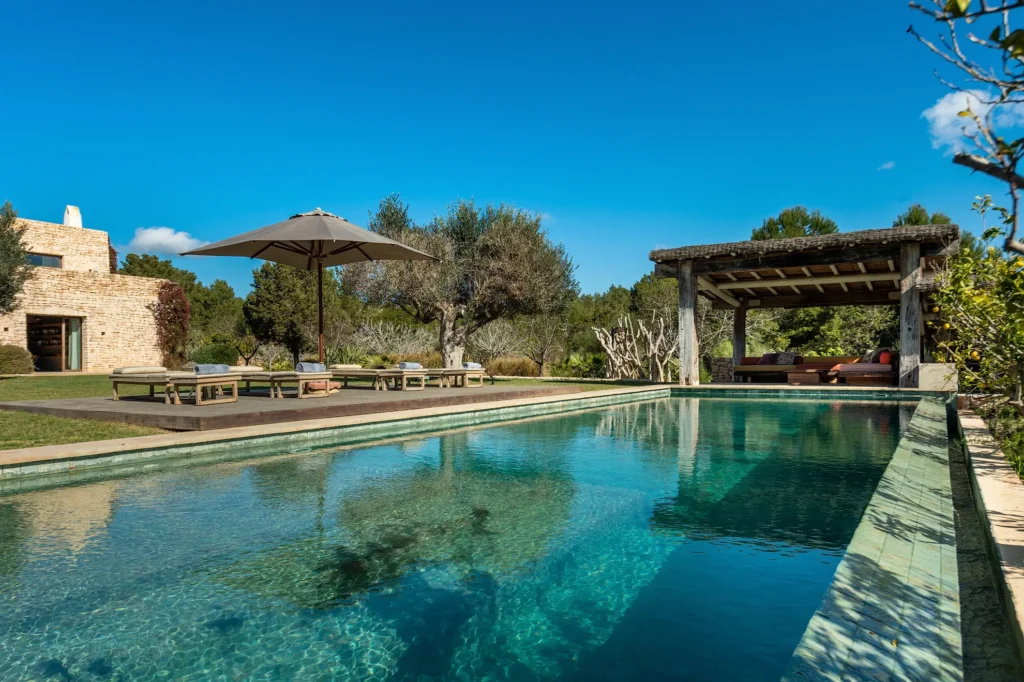Manicured Mediterranean gardens and lush landscaping surrounding the private pool area.